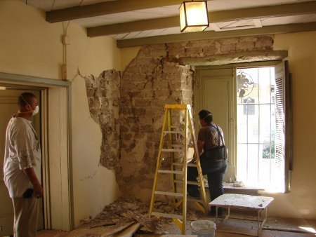 Cracked adobe is visible where the plaster has been removed, 2012.