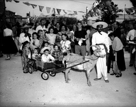 Children of O'Neil and Wanda Ford ride in a goat cart, 1955.