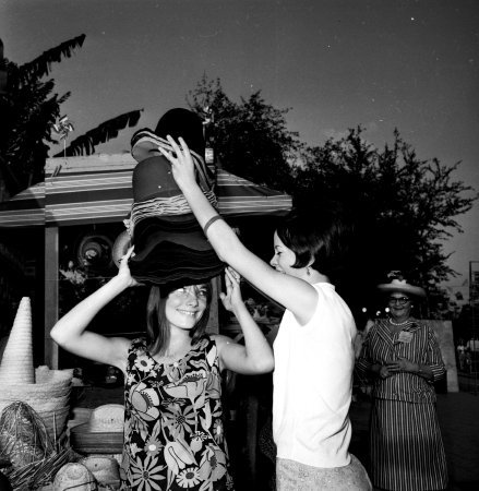 Girls trying on hats from the NIOSA Sombrero Wagon, 1975.