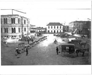 San Antonio City Hall under construction, c. 1890. The former city hall, known as the "Bat Cave" is in the center.