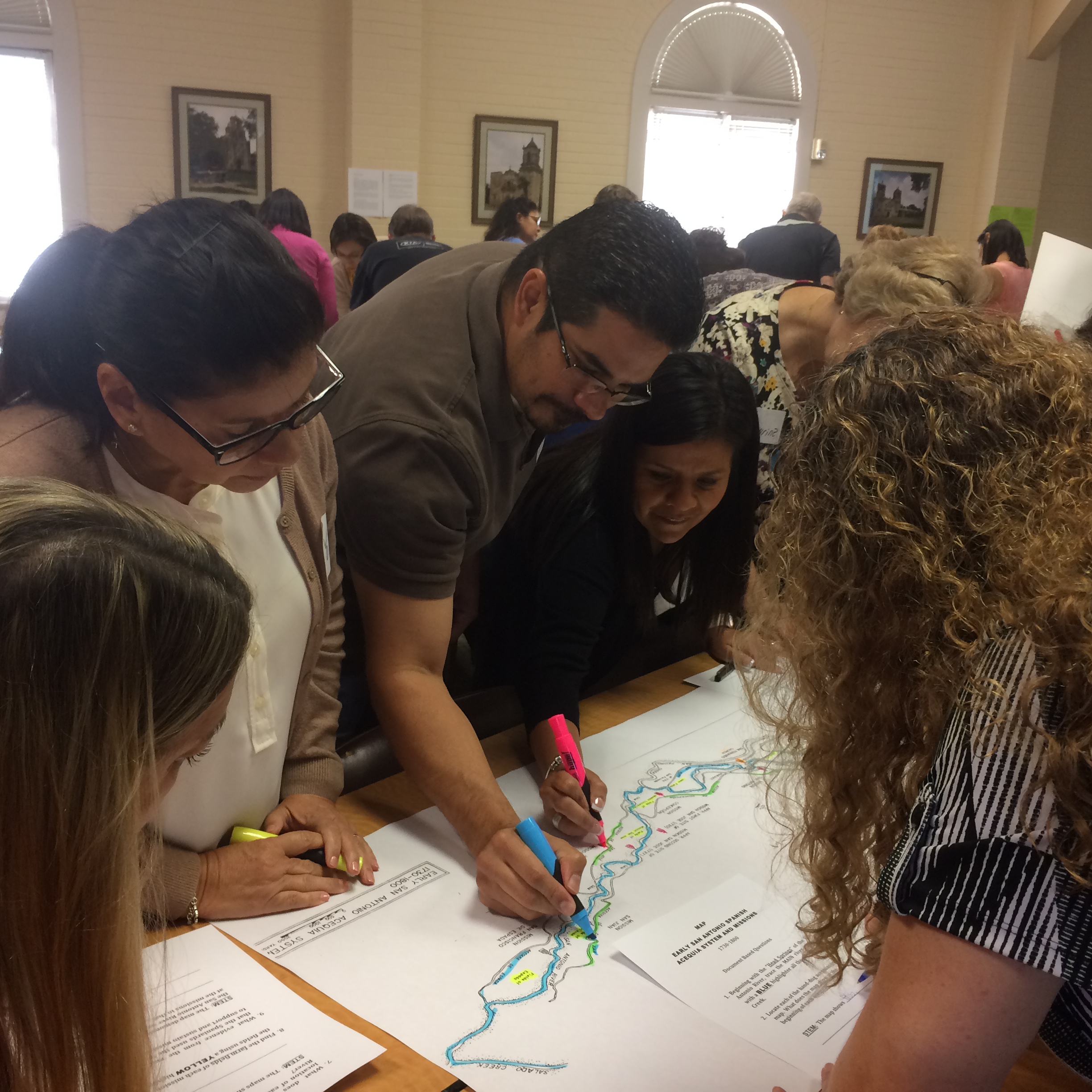 Small group of teachers marking river paths on workshop materials during Teacher Education Seminar in the River House