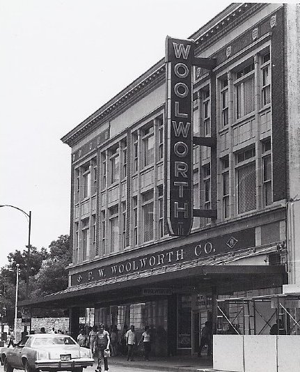 The Houston Street facade of the Woolworth building features a large blade sign with the company name.