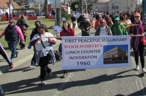 Marchers carrying the Coalition for the Woolworth Building's banner: "First Peaceful Voluntary Woolworth's Lunch Counter Integration 1960