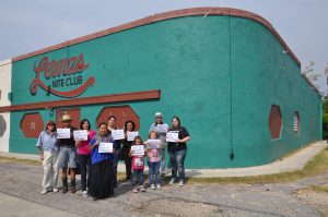 Community supporters hold signs reading, "Esta lugar es importante - This place matters," in front of Lerma's Nite Club.