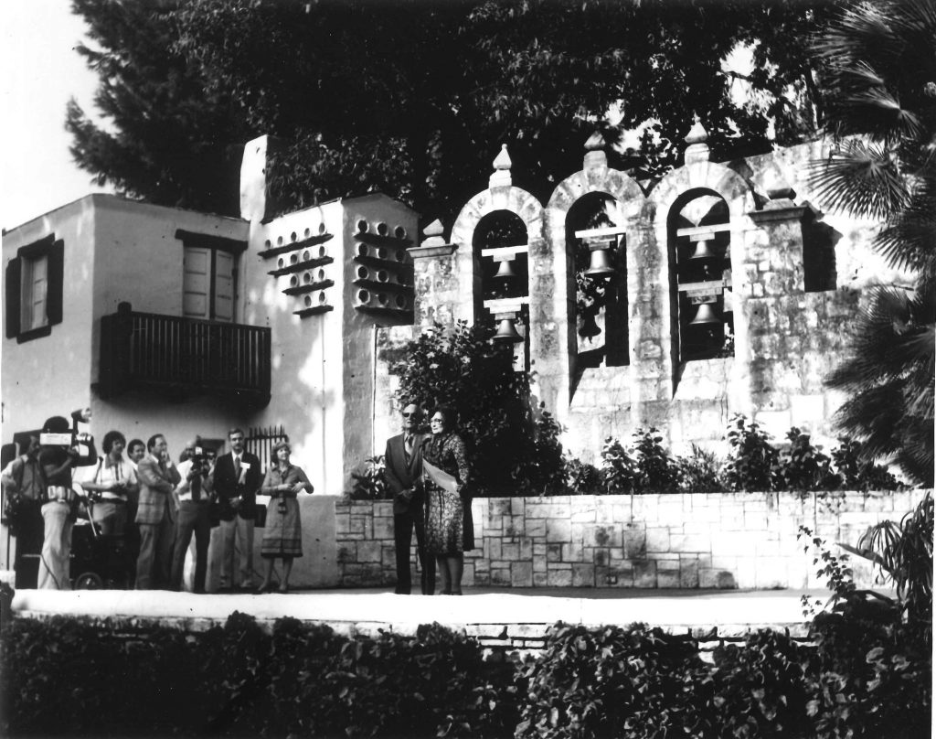 River walk designer Robert Hugman stands next to Mayor Lila Cockrell on the stage of the Arneson River Theater in front of the bells dedicated in his honor.