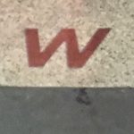 W in Woolworth name on pavement